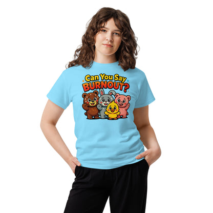 A woman modeling a light blue graphic t-shirt with the text 'Can You Say BURNOUT?' and cartoon animals (a bear, bunny, duck, and pig) on the front, paired with black pants against a plain white background.