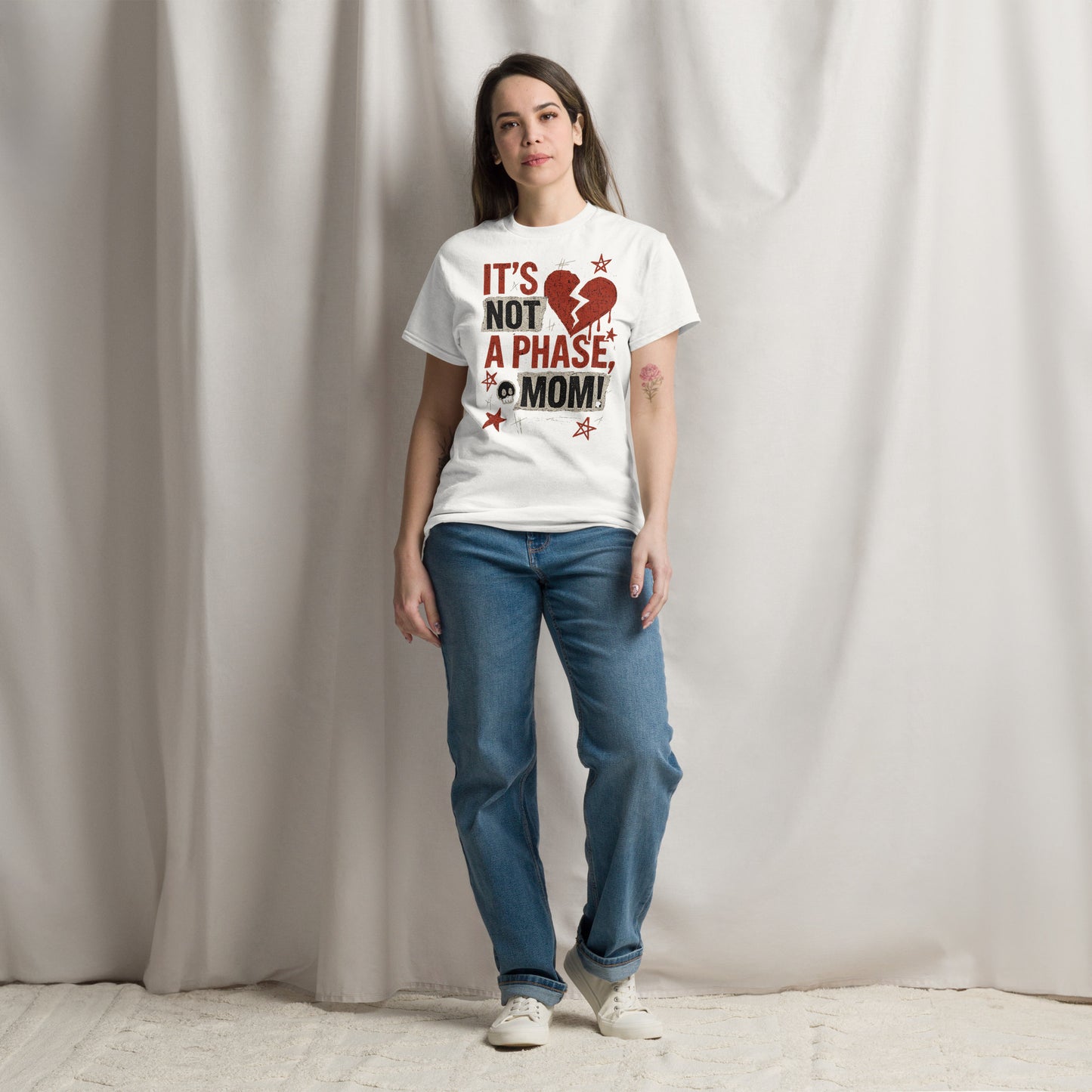 Woman wearing a white t-shirt with a red and black graphic and text, standing against a plain background.