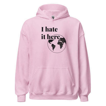 Pink hoodie with 'I hate it here' text and world map design on a white background