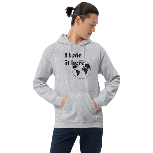 Person wearing a gray hoodie with 'I hate it here' text and world map design on a white background