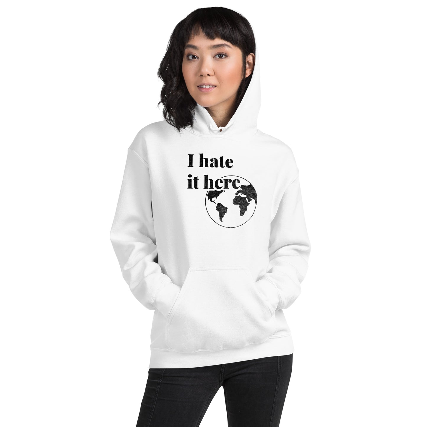 Person wearing a white hoodie with 'I hate it here' text and world map design on a white background