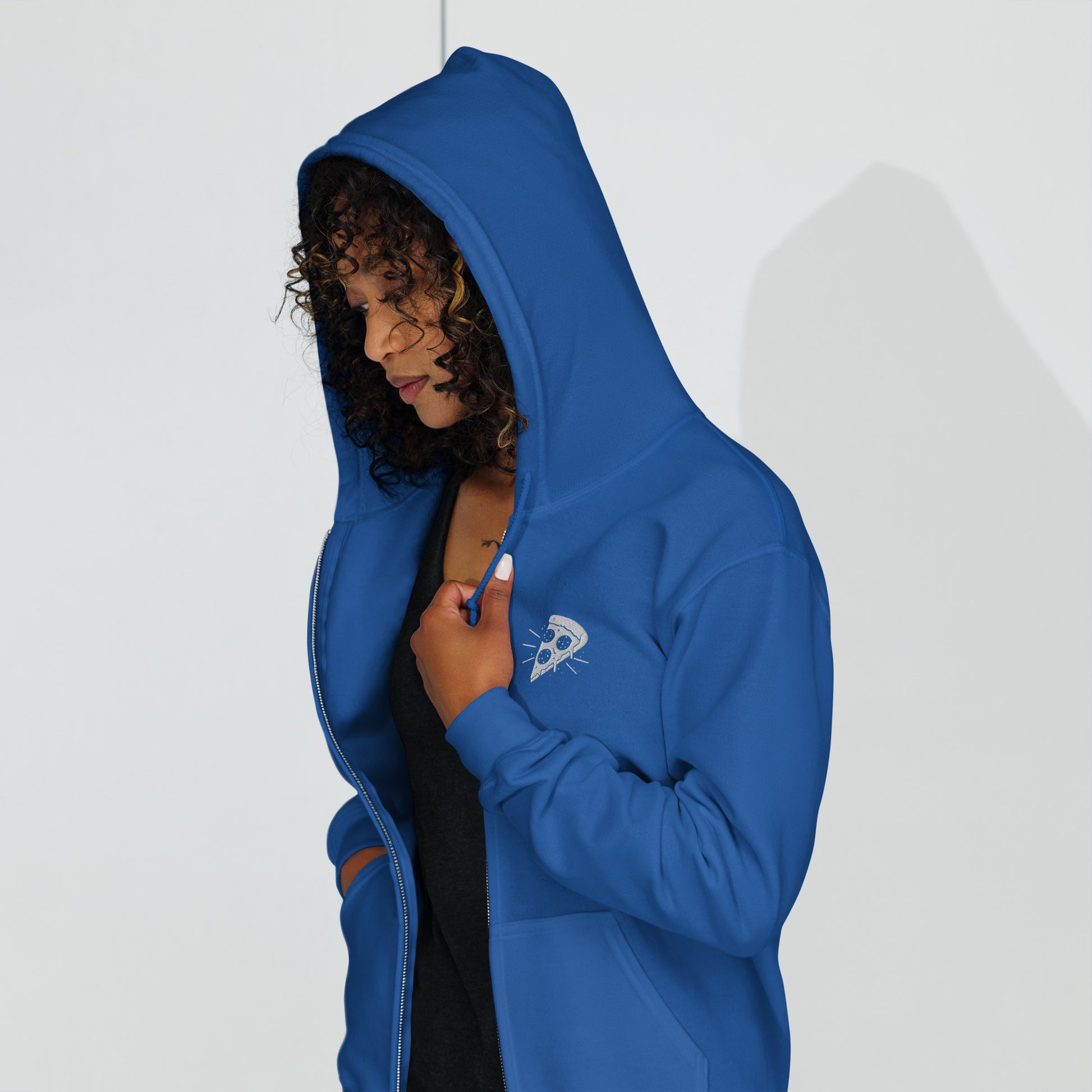 Person wearing a blue hoodie with a small logo on a white background