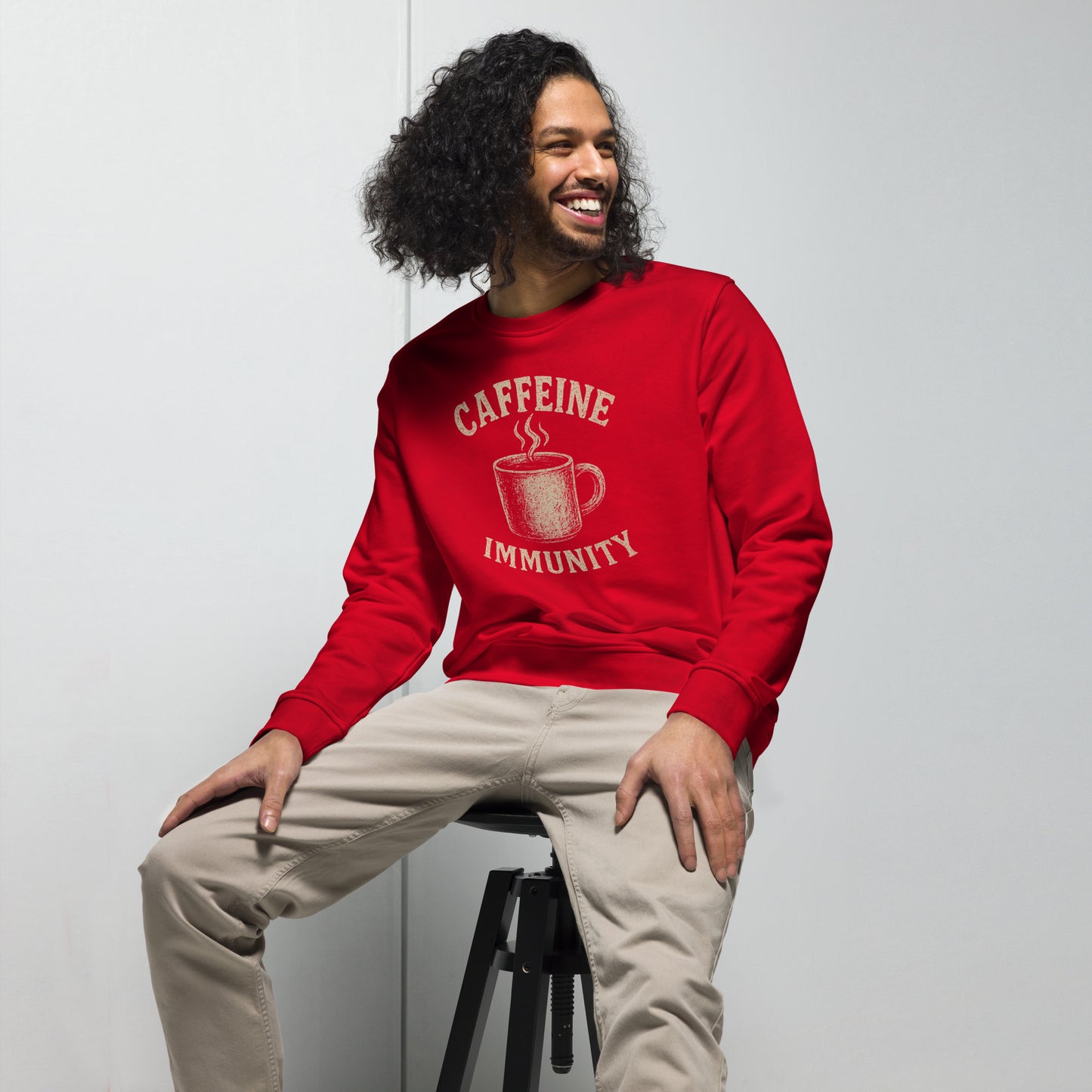 Person wearing a red sweatshirt with 'CAFFEINE IMMUNITY' text and coffee cup graphic.