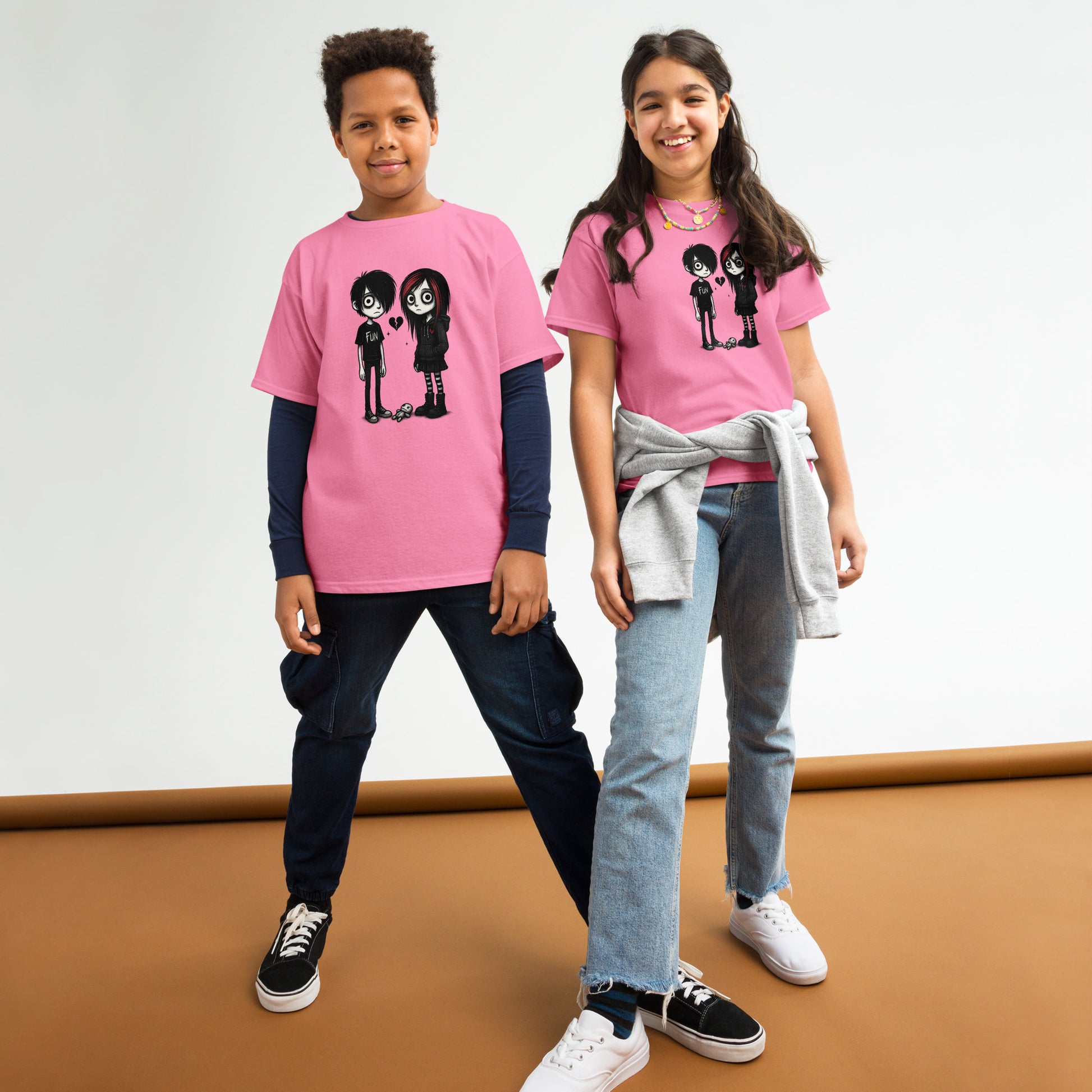 Two children wearing pink t-shirts with a graphic design on a white background.